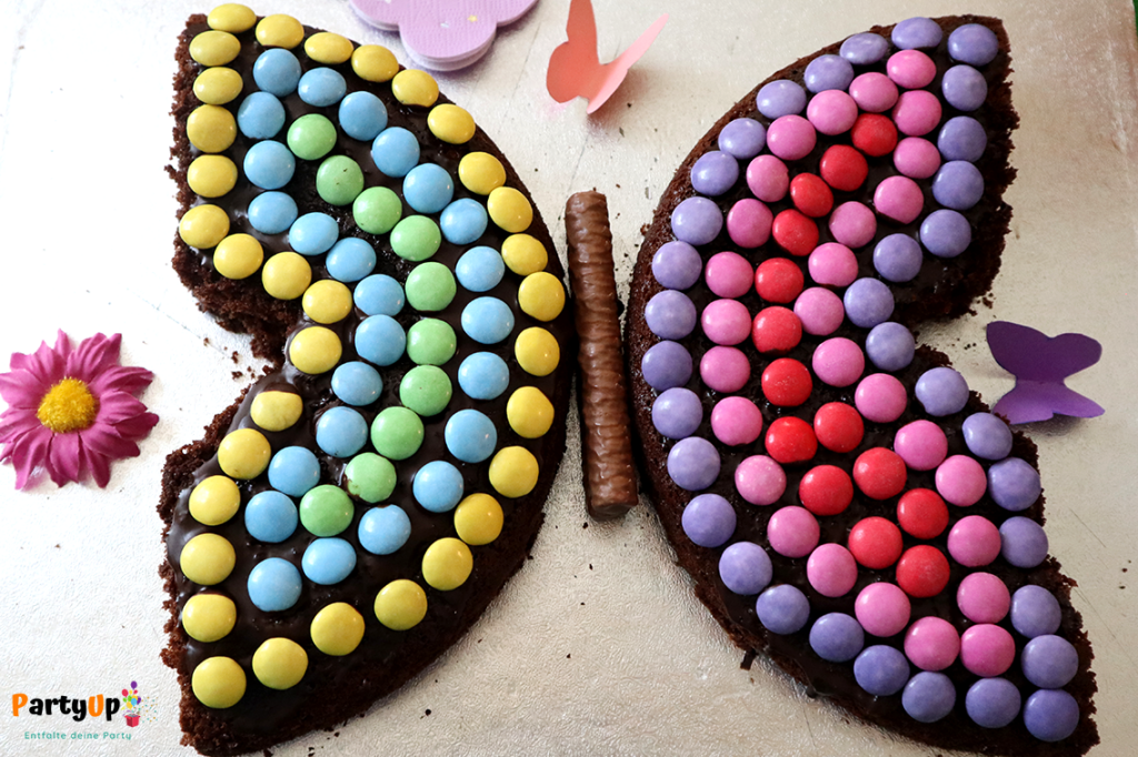 Schmetterling Kuchen aus Schokolinsen und Schokoladenkuchen für den Kindergeburtstag